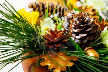 Christmas dinner table decoration with pine branches and golden cones. Christmas centerpiece with golden decor. Christmas party background.
