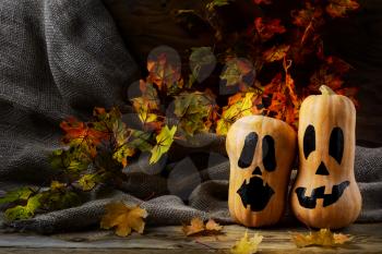 Halloween smiling butternut squash on dark rustic background. Halloween symbol jack-o-lantern background. 