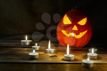 Halloween symbol smiling pumpkin lantern and burning candles. Halloween jack-o-lantern and burning candles background. 