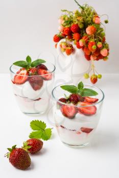 Layered strawberries cream cheese dessert on white background. Diet yogurt dessert with ripe strawberry.