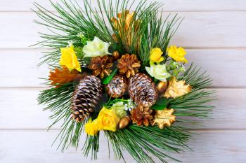 Christmas table centerpiece or door wreath with golden cones. Christmas decoration with golden decor. Christmas party background.