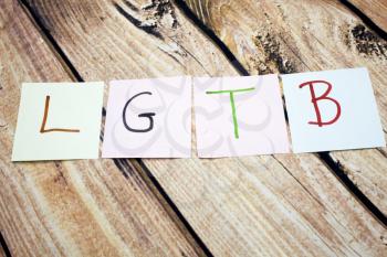 Handwritten colorful LGBT word on white paper above retro wooden bark background. Conceptual image about equal human rights. Gay and lesbian concept images.