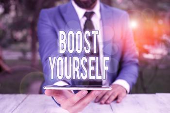 Conceptual hand writing showing Boost Yourself. Concept meaning to make yourelf feel more positive or more confident Businessman with mobile phone in his hand