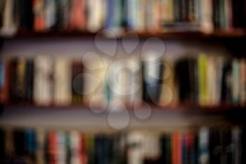 Shelves with books in a blurred background. Learning concept with blurred library books on the shelves. Abstract colorful blurred background with books.