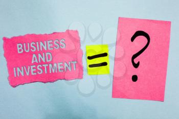 Conceptual hand writing showing Business And Investment. Business photo showcasing putting your money in field to increase them Pink paper equal sign question mark asking important answer