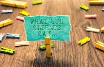 Word writing text What Our Clients Say.... Business concept for your customer feedback using poll or written paper Clothespin holding turquoise paper note several clothespins wooden floor