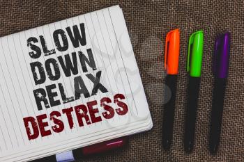 Text sign showing Slow Down Relax Destress. Conceptual photo calming bring happiness and put you in good mood Open notebook page jute background colorful markers Expressing ideas