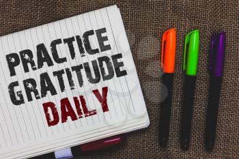 Text sign showing Practice Gratitude Daily. Conceptual photo be grateful to those who helped encouarged you Open notebook page jute background colorful markers Expressing ideas