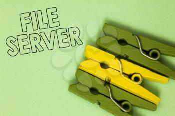 Text sign showing File Server. Conceptual photo device which controls access to separately stored data Three green yellow vintage clothespins clear background Holding things