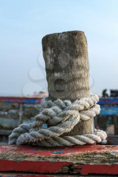 Rope coiled around a wooden post on a boat at Dungeness