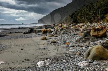 Stormy weather approaching a rock strewn beach in New Zealand