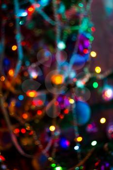Decorated Christmas tree and colorful garland lights, defocused background, bokeh effect.