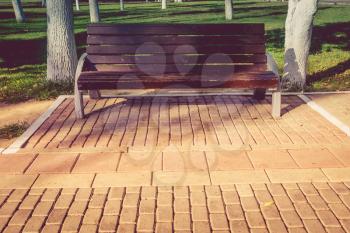 Vintage lonely wooden bench in the city park.