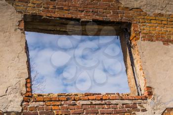 Old crumbling brick house, windows in ruined abandoned building background.