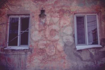 Old walls with cracked plaster and two windows.