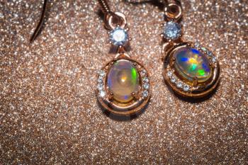 Fashion golden earrings with a bright rainbow flash opal stone.