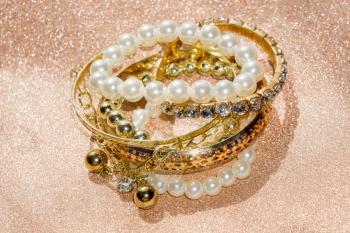Stylish fashion bracelets with acrylic beads, pearls on glittering background.
