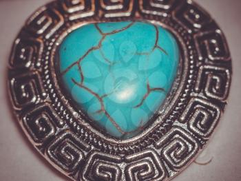 Big natural turquoise stone in a shape of a heart in metal frame.