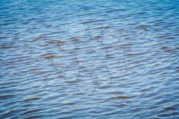 Wavy water surface of the small river, close up photo.