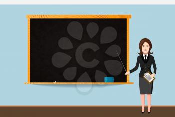 Woman teacher in black suit with empty school chalkboard in wooden frame with chalk and sponge on shelf in bright classroom