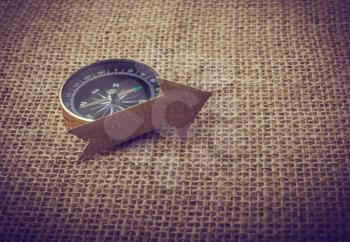 Compass and  paper arrow on a canvas background