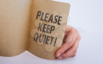 Hand holding a Keep Quiet note as Business concept
