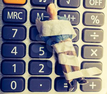 Tiny figurine of man model wrapped in bandages calculator