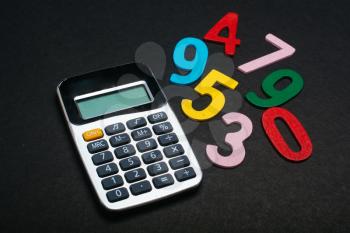 Mathematics learning concept. Colored numbers beside calculator.