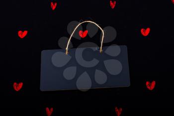 Rectangular shaped black notice board  and red hearts on black background