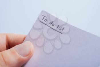 hands making a to-do list in a piece of paper