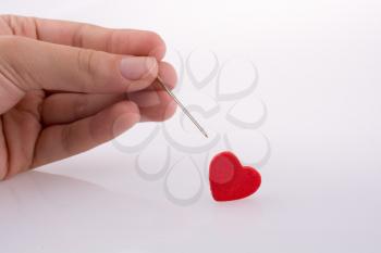 Hand pointing a needle on a heart