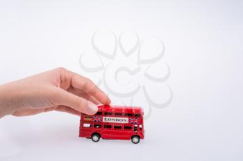 Child hand playing with London double decker bus  model on white background
