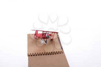 Airplane and notebook on white background