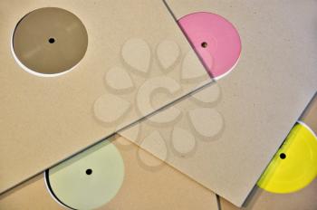 Cardboard sleeve vinyl music records with colorful blank labels.