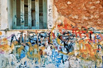 Abandoned house wall covered with messy graffiti.