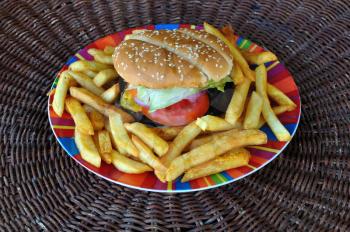 Beef cheeseburger and french fries plate. Fast food background.