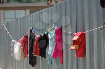 Laundry drying on metal fence. Urban street scene.