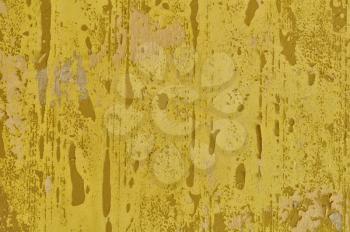 Peeling paint yellow wall and pieces of torn wallpaper. Background texture.