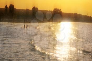 Children playing at the beach. Sunset light leaking on sea water vintage style photo composite.