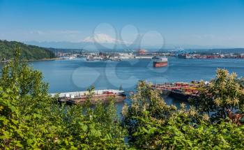 Ships come and go in the busy Port of Tacoma. Mount Rainier is in the distance.