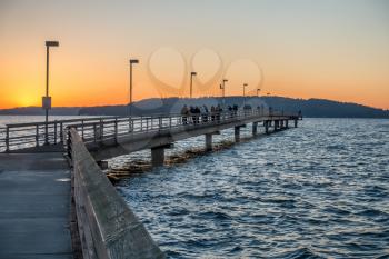 View of the fishing pier in Des Moines, Washington at sunset.