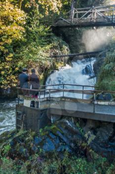 An artistic rendition of lower Tumwater Falls with onlookers.