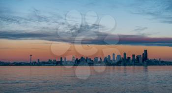 The sun sets creating an eerie glow over the Seattle skyline.