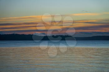 A view of a hazy sunset with a fence from West Seattle, Washington.