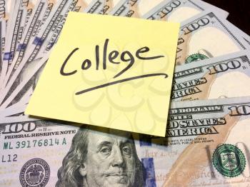 Post it note with handwritten text college on money low angle view