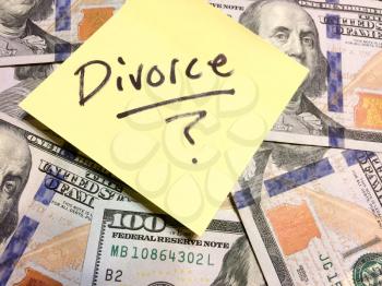 American cash money and yellow post it note with text Divorce with question mark in black color aerial view