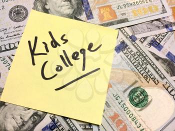 American cash money and yellow post it note with text Kids College in black color aerial view