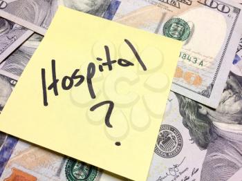 American cash money and yellow paper note with text Hospital with question mark in black color aerial view