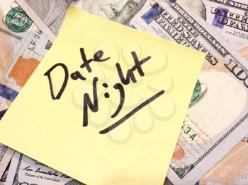 American cash money and yellow sticky note with text Date night in black color aerial view