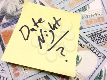 American cash money and yellow sticky note with text Date night with question mark in black color aerial view